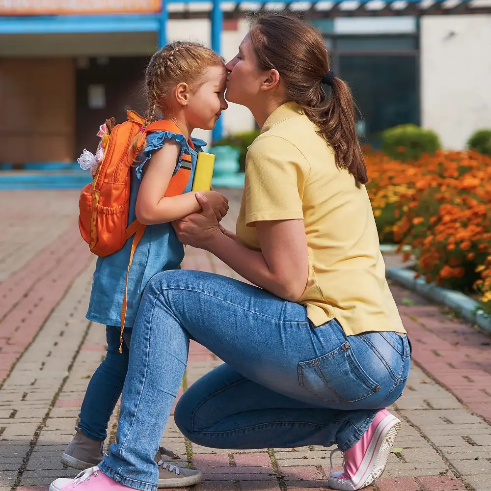 A child hugging a parent at school drop-off